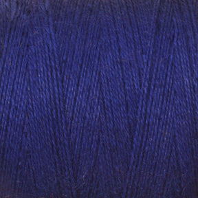 Close-up image of a spool of dark blue 8/2 Cottolin Organic Yarn from Maurice Brassard, showing the texture, fibers, and layering pattern as it is wound tightly around the tube. The rich cotton linen blend displays vibrant color variations due to the lighting and natural sheen of the material.