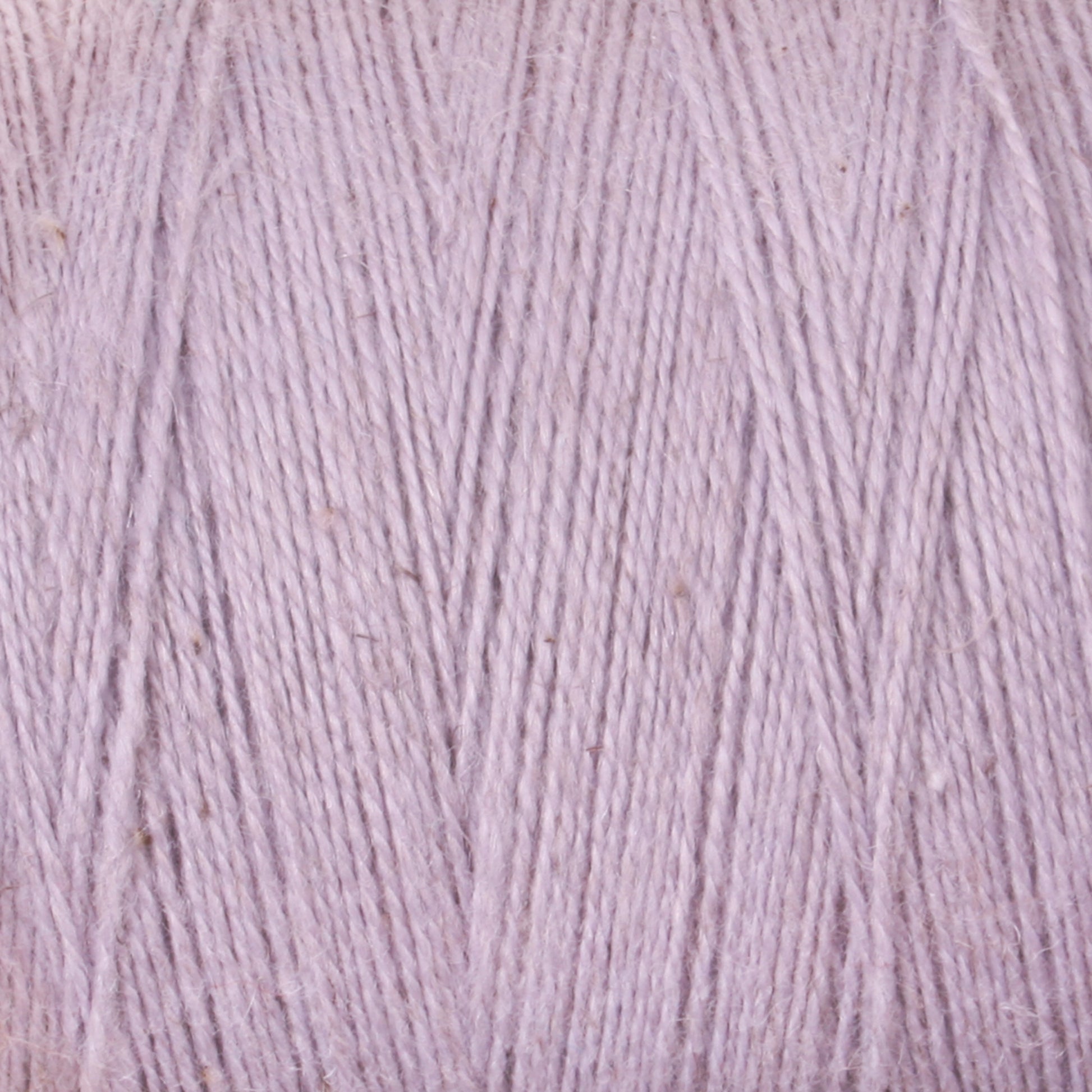 Close-up image of light lavender colored yarn. The texture of the Maurice Brassard 8/2 Cottolin Organic Yarn is visible, showing a soft and slightly fuzzy appearance with some minor irregularities in the strands, perfect for your Four Shaft Loom projects or even a Cottolin Tea Towel Kit.