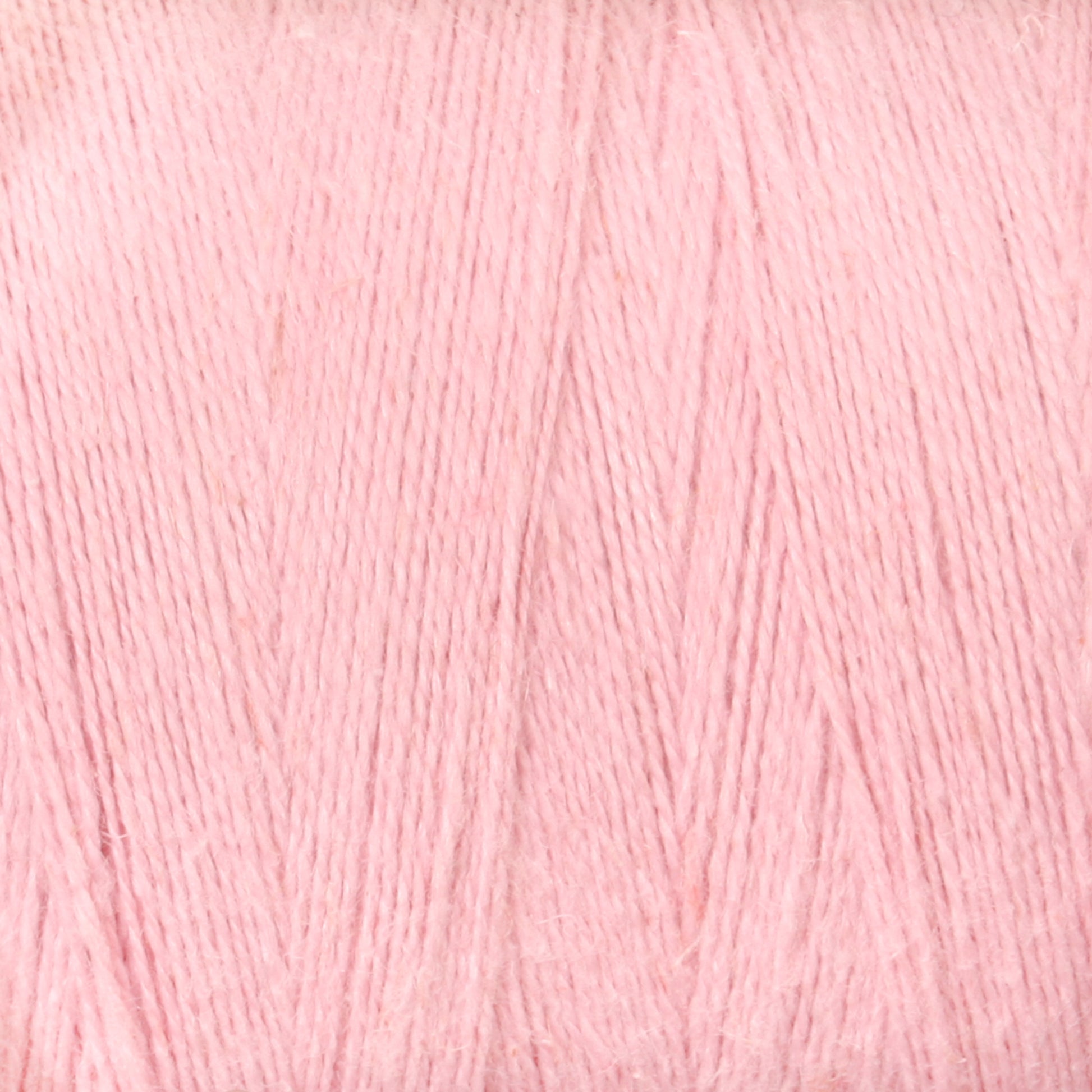 A close-up image of a ball of Maurice Brassard's 8/2 Cottolin Organic Yarn | Tube in light pastel pink. The yarn appears soft and finely woven, with a consistent and smooth texture, giving it a gentle and delicate appearance—perfect for use in the Cottolin Tea Towel Kit on your four shaft loom.