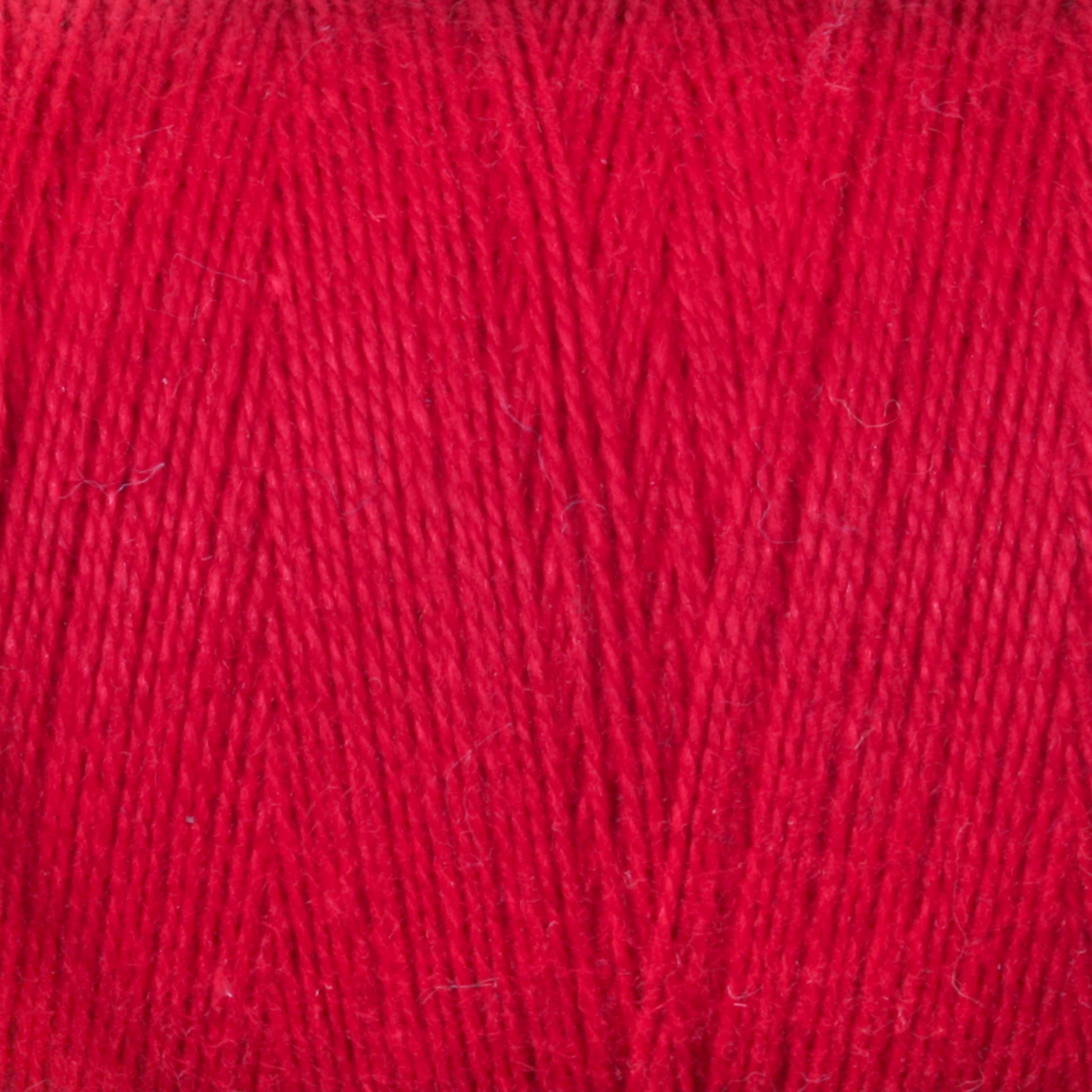 A close-up view of the vibrant red 8/2 Cottolin Organic Yarn from Maurice Brassard, showcasing its fine fibers and intricately twisted strands. The texture appears soft and slightly fuzzy, indicating it is ideal for knitting or crocheting projects. Perfect for use in a Cottolin Tea Towel Kit, the image clearly captures the yarn's color and material details.