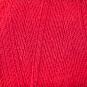 Close-up image of the 8/2 Cottolin Organic Yarn by Maurice Brassard, showcasing the bright red color and the texture of tightly wound fibers. This yarn, reminiscent of those found in a four shaft loom project, appears soft and suitable for knitting or crocheting projects.