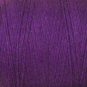 A close-up view of a spool of 8/2 Cottolin Organic Yarn from Maurice Brassard. The texture of the cotton linen blend yarn is clearly visible, with tightly wound fibers creating a consistent pattern. The color is rich and vibrant, showcasing various shades of deep purple under the light, making it perfect for your four shaft loom project.