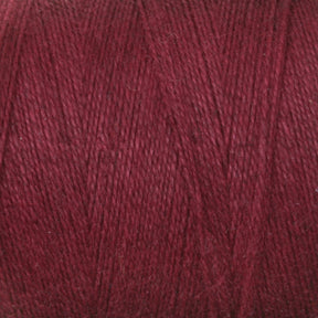 A close-up image of a spool of Maurice Brassard 8/2 Cottolin Organic Yarn in a deep, dark red hue, perfect for weaving on a four shaft loom. The texture is clearly visible, showcasing tightly wound, thin strands with a slight sheen. The rich and uniform color makes it an ideal choice for the Cottolin Tea Towel Kit.