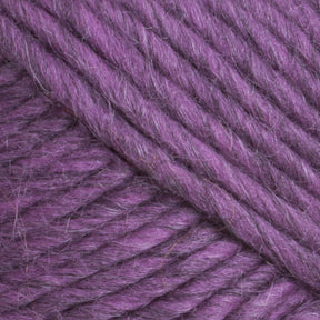 Close-up of thick, soft fibers from Lamb's Pride Bulky Yarn by Brown Sheep intertwined, creating a textured pattern. The fluffy and dense yarn, in light and dark purple hues, evokes cozy warmth perfect for knitting Icelandic sweaters or woven blankets. Ideal material for passionate knitters and crocheters.