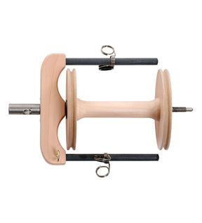 Image of the Ashford Sliding Hook Flyer & Bobbin Joy Wheel by Ashford Handicrafts Limited. The wooden yarn bobbin, used for spinning wool, is placed between two metal supports with U-shaped hooks, likely part of a spinning wheel setup. The central wooden rod has flanges at both ends, and there is a metal axle extending from one side.