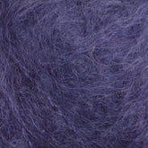 Close-up of Victorian Brushed Mohair Yarn | Mini Skein by Caledonian Dye Works: a soft, fuzzy, purple fabric with fibers and threads creating a textured, tangled appearance. The rich color and luxurious mohair provide the fabric with a consistent and opulent appeal throughout.