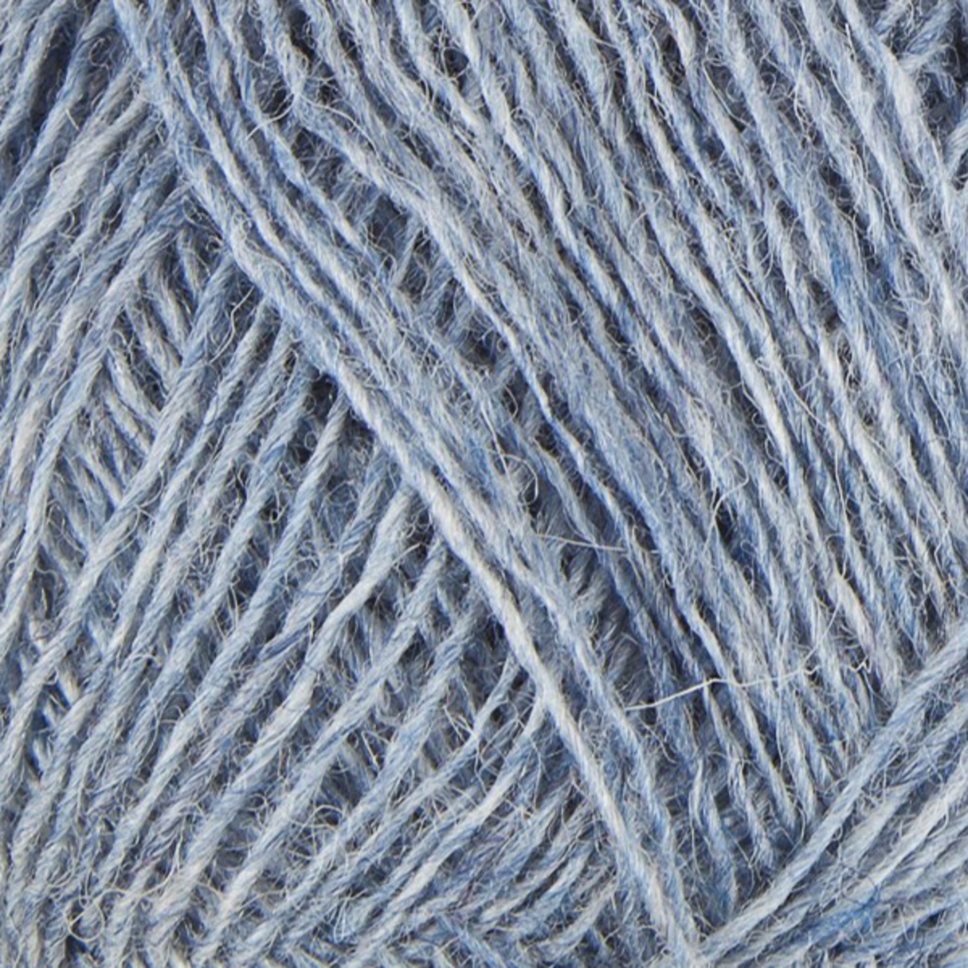 Close-up of Einband Lopi yarn in blue and white. The texture reveals twisted and interwoven fibers, crafting a dense and intricate pattern. The composition highlights the soft, fuzzy nature of this yarn from Berroco, Inc., reminiscent of Icelandic wool, making it ideal for lace knitting or crocheting projects.