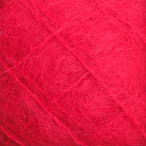 Close-up image of the Victorian Brushed Mohair Yarn | Mini Skein by Caledonian Dye Works, showcasing its fuzzy, red texture with fine fibers and faint diagonal lines, which create a soft and textured appearance. The luxurious mohair imparts an unmistakable richness to the yarn.