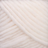 Close-up view of thick, soft, white yarn arranged in diagonal lines. The yarn has a fluffy texture and subtle sheen, suggesting it is made from a natural fiber blend—ideal for Brown Sheep's Lamb's Pride Worsted Yarn or Navajo style weaving.