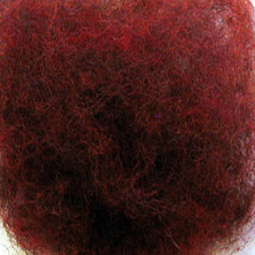 Close-up view of a dense, tangled mass of Harrisville Dyed & Carded Wool Fiber. The texture appears woolly and chaotic, with heathered colors intermingling throughout the shades of red and brown. Perfect for felting enthusiasts or those working on projects with Harrisville Designs' wool products.