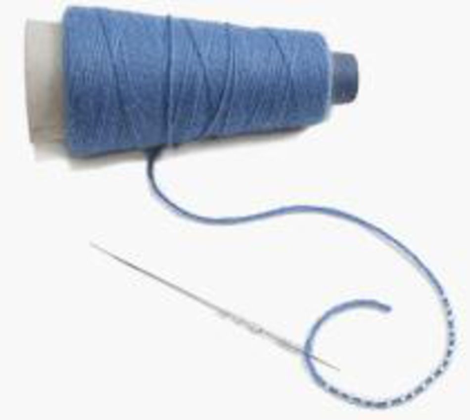 A blue thread cone with loose thread extending, accompanied by a Lacis Big Eye Needle for Beading threading part of the loose thread. The coiled thread gently curves next to the needle on a plain, light-colored background, resembling the delicate start of knitting with beads.