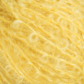 A close-up image of Caledonian Dye Works' Victorian Bouclé Mohair Yarn. The yellow yarn is fluffy and textured, with soft and curly fibers that give it a cozy and inviting appearance—perfect for creations inspired by Halcyon's Signature Victorian Collection.