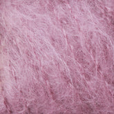 Close-up image of soft, fuzzy pink Victorian Brushed Mohair Yarn from Caledonian Dye Works with a textured appearance. The fibers are interwoven, giving the luxurious mohair material a delicate and fluffy look.