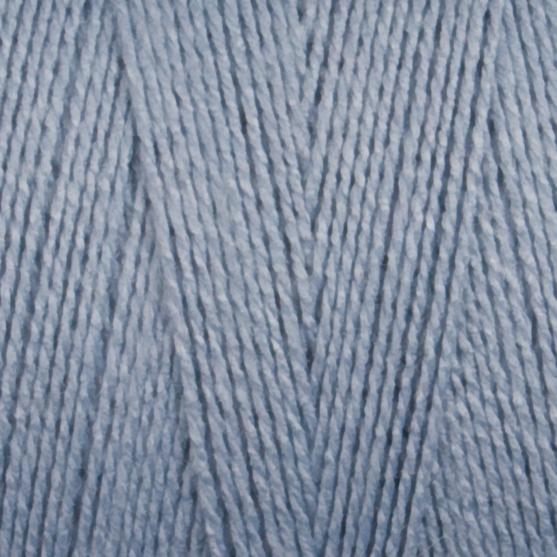 Close-up of Maurice Brassard's 8/2 Bamboo Yarn wound tightly on a Mini-cone, revealing the intricate fibers and texture. This environmentally friendly yarn has a soft, smooth appearance with a slight sheen, hinting at its softness and suitability for knitting or crocheting projects.