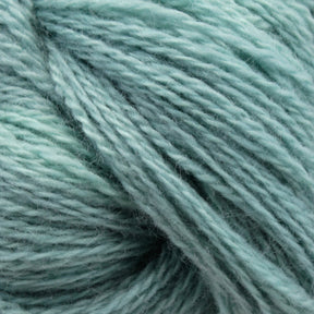 Close-up image of Jade Sapphire Cashmere 2-Ply yarn from Jade Sapphire Exotic Fibres in a soft, light mint green hue. The yarn strands are loosely twisted, revealing its fibrous texture and delicate appearance, making it perfect for creating finely knit sweaters or other elegant woven accessories.