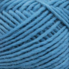 Close-up image of a ball of Brown Sheep's Lamb's Pride Worsted Yarn in light blue, tightly wound and showcasing its soft, fibrous texture. The thick yarn strands are neatly looped, highlighting the intricate pattern they form—perfect for felting projects.