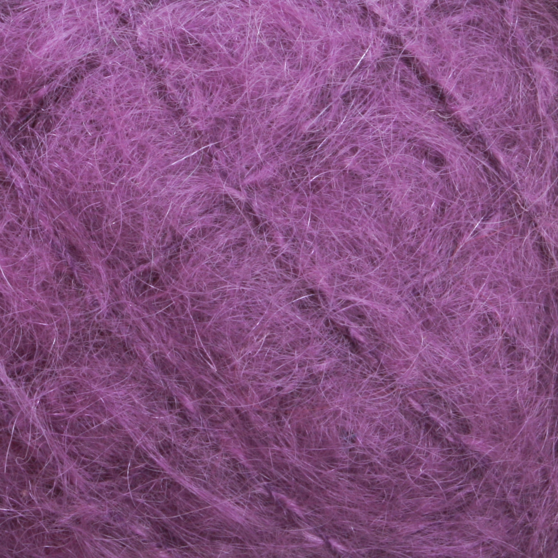 Close-up view of a ball of luxurious Victorian Brushed Mohair Yarn | Mini Skein from Caledonian Dye Works, showcasing its fuzzy texture with intricate loops and fibers.