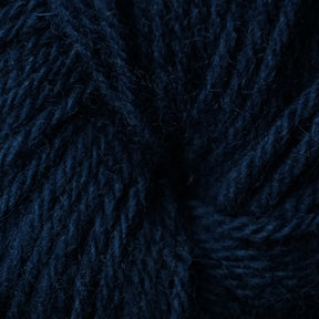 Close-up image of dark blue Halcyon Deco Rug Wool, showing the texture and individual strands in detail. The yarn, made by Caledonian Dye Works from 100% wool, appears thick and soft with a rich, deep navy blue color. This versatile yarn promises both aesthetic appeal and durability for various crafting projects.