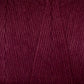 A close-up view of Maurice Brassard's Cotton 8/8 Carpet Warp in a deep burgundy hue reveals its tightly wound, smooth strands, ideal for knitting or crocheting. Made from unmercerized cotton, the rich color lends a warm and elegant appearance to the yarn.