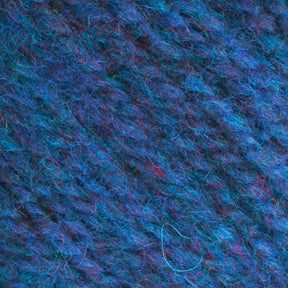 A close-up view of Bartlettyarns Maine Wool Yarn from Bartlettyarns reveals an exquisite blend of blue wool interspersed with heathered colors, including subtle purple and pink fibers. The texture is soft, fluffy, and slightly fuzzy, highlighting the intricate pattern of the worsted weight yarn strands.