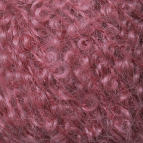 Close-up image of soft, pink curly fibers, resembling textured yarn or fur. The tight curls and vibrant color create a dense and fluffy appearance, reminiscent of Caledonian Dye Works' Victorian Bouclé Mohair Yarn.