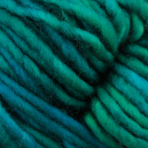 Close-up of thick, soft Malabrigo Mecha yarn in shades of green and blue, showing the texture and tightly twisted strands. This superwash bulky yarn from Malabrigo Yarn has a beautiful, kettle-dyed finish that enhances its rich hues.