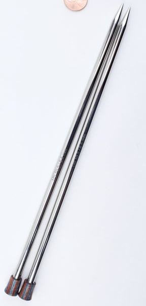 Close-up view of two metallic Accessories Unlimited Nova Platina Single Point Knitting Needles positioned parallel to each other on a white background. The needle tips are pointed and reflect light, while the opposite ends have colored ends. A copper coin is partially visible at the top.