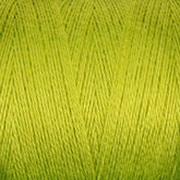 Close-up image of lime green 8/2 Bamboo Yarn by Maurice Brassard, showcasing tightly woven fibers. The texture appears smooth and soft, making it ideal for knitting or crocheting projects. This environmentally friendly mini-cone yarn boasts a vibrant and uniform color, creating a visually appealing surface that knitters will adore.