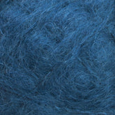 A close-up image showcasing the luxurious fibers of Caledonian Dye Works' Victorian Brushed Mohair Yarn | Mini Skein in various shades of blue. The texture is thick, soft, and fluffy, with the natural fibers intricately tangled and densely packed, evoking a rich and tactile feel reminiscent of Victorian yarns.