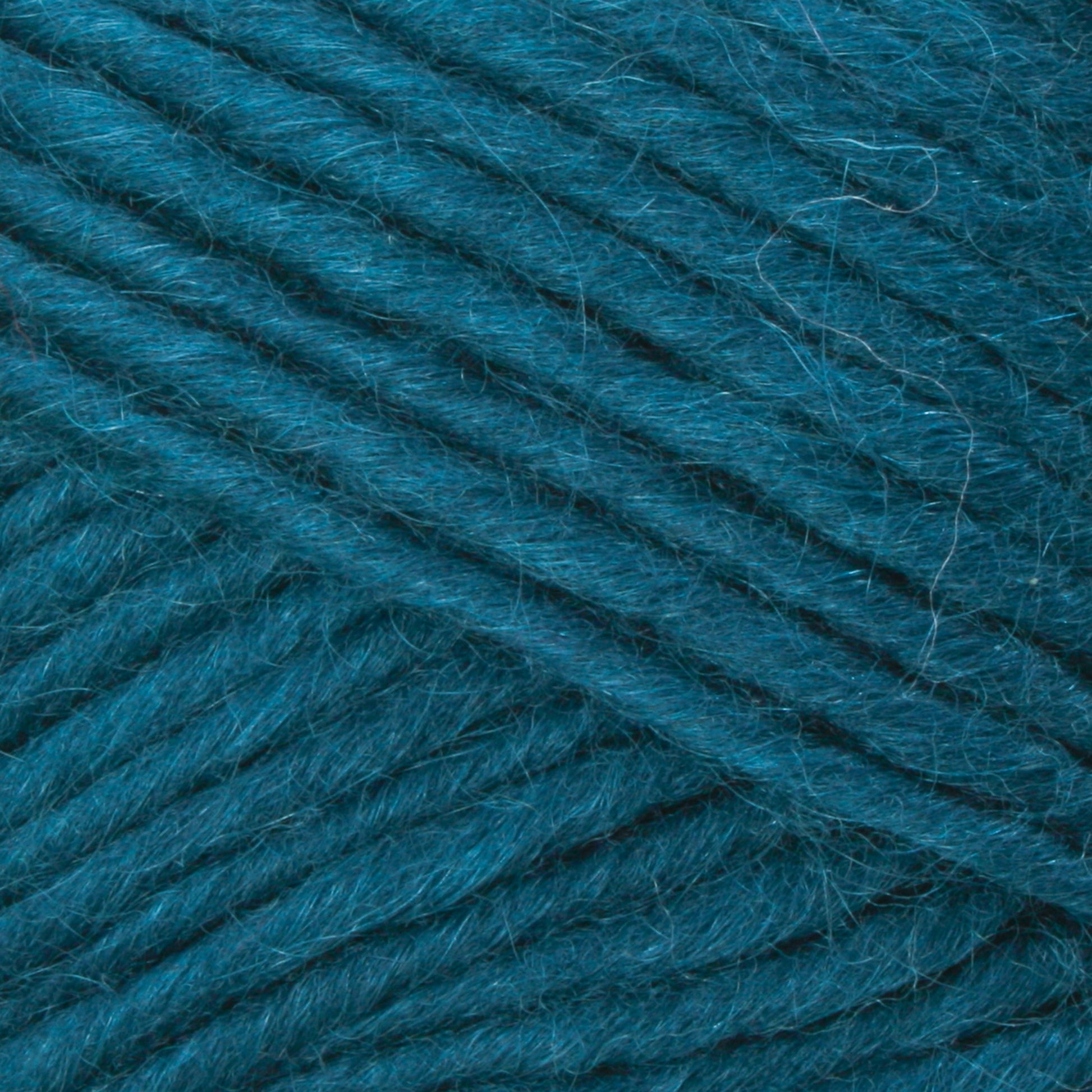 Close-up image of Brown Sheep's Lamb's Pride Bulky Yarn in a rich teal color. The yarn showcases a smooth, slightly fuzzy texture with neatly wound parallel strands. The consistent teal hue highlights its soft and cozy appearance—ideal for knitters and crocheters creating Icelandic sweaters.