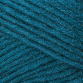 Close-up image of Brown Sheep's Lamb's Pride Bulky Yarn in a rich teal color. The yarn showcases a smooth, slightly fuzzy texture with neatly wound parallel strands. The consistent teal hue highlights its soft and cozy appearance—ideal for knitters and crocheters creating Icelandic sweaters.