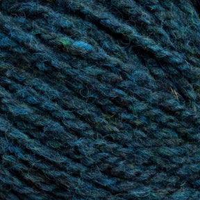 Close-up image of dark blue and green Harrisville Shetland Yarn - Unwashed Cones by Harrisville Designs, showcasing its textured, intertwined pattern with a mix of hues and soft, fibrous strands, perfect for creating lightweight blankets.