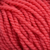 Close-up view of thick, red Norumbega Aran weight yarn from Caledonian Dye Works, twisted into multiple strands, showing its soft and slightly fuzzy texture. The bright, vibrant color and tightly woven fibers of this 100% U.S. wool indicate its suitability for knitting or crocheting warm, cozy garments or accessories.