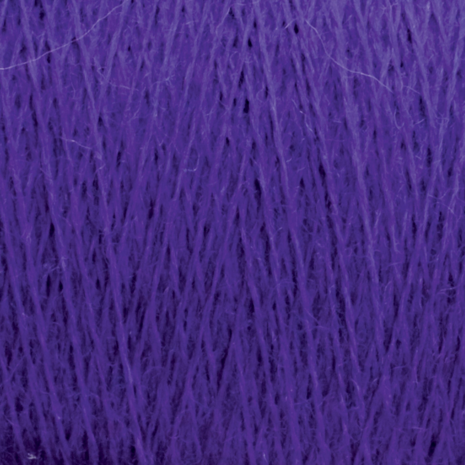 A close-up image of JaggerSpun Maine Line 3/8 Yarn in a mini-cone, showcasing its fine texture and slightly fuzzy appearance. The strands are tightly wound together, creating a dense and rich purple hue characteristic of Jagger Brothers, Inc. yarns.