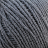 Close-up image of a ball of Baby Blatt by Anny Blatt gray baby yarn with thick strands. The texture of the yarn is visible, showcasing its soft and slightly fuzzy appearance, suitable for knitting or crocheting projects. This machine washable yarn from Essentially Felt Studio & Fine Yarn ensures both convenience and comfort for all your creations.