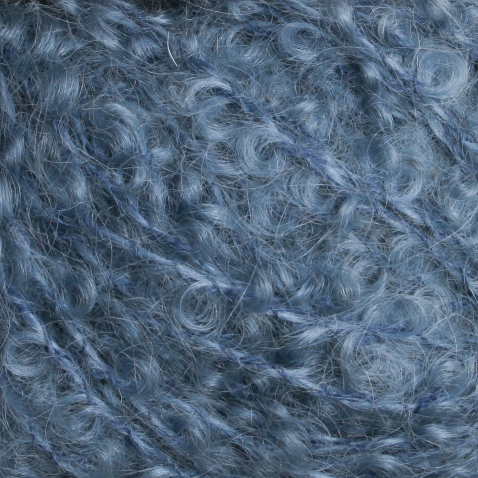 Close-up image of soft, curly blue fibers intertwined together. The texture appears fluffy and delicate, reminiscent of Victorian Bouclé Mohair Yarn by Caledonian Dye Works, typically used for knitting or crocheting. The overall appearance is cozy and inviting.