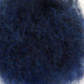 Close-up photograph of a single piece of Harrisville Dyed & Carded Wool Fiber by Harrisville Designs, showcasing its fine, tangled fibers and rough texture. The fibers appear densely packed, resembling the complexity of steel wool, giving the material a coarse and intricate appearance.