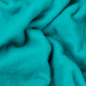 Close-up of the Merino Prefelt from Europa Wools Ltd, displaying its soft, turquoise Merino wool fabric with a slightly fuzzy texture. The gathered and folded material casts gentle shadows and variations in color intensity, making it perfect for intricate felting projects.