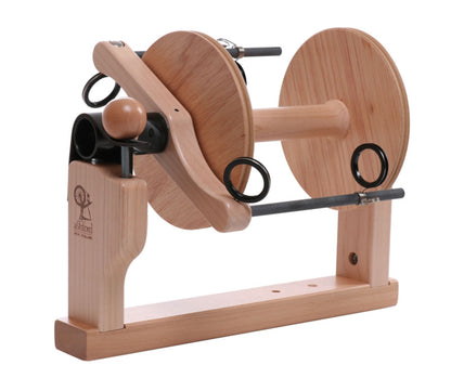 The Ashford Kiwi Super Flyer Kit by Ashford Handicrafts Limited is a wooden yarn winder featuring an Ashford logo, two large spools, and a handle for manual operation. It boasts a sturdy rectangular base with curved supports and is designed for use in spinning or winding yarn.