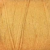 A close-up image of a spool of Maurice Brassard's 8/2 Cottolin Organic Yarn in a warm, golden-yellow hue. The fine-gauge texture showcases subtle fibers and gentle twists, ideal for crafting cozy tea towels. Made from a cotton-linen blend, this yarn offers an inviting appearance suitable for knitting or crocheting projects.