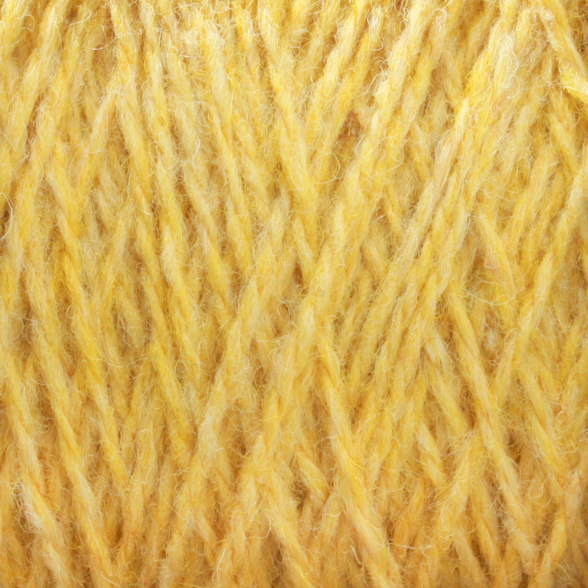 Close-up image of yellow unscoured yarn in a tightly woven pattern, highlighting the texture and fiber details. The strands of Harrisville Highland - Cones yarn from Harrisville Designs appear soft, slightly fuzzy, and hint at the presence of spinning oils.