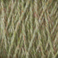 Close-up image of green Harrisville Designs Harrisville Highland - Cones yarn with a blend of orange and beige fibers intertwined. The texture appears soft and fluffy, showcasing the detailed strands of this unscoured yarn.