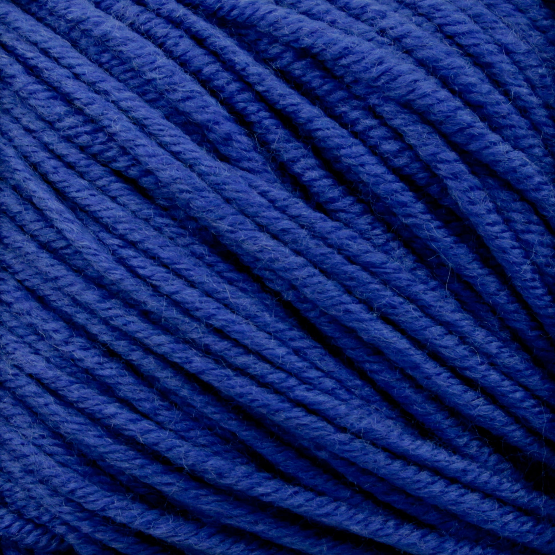 Close-up image of Plymouth Select Worsted Merino Superwash blue yarn by Plymouth Yarn Co., tightly wound in a ball. The texture is smooth with visible strands twisted together, creating a consistent and dense pattern, enhancing stitch definition.