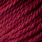 Close-up image of Jo Sharp Silkroad Ultra by Kingfisher Yarn & Fibre, tightly wound in a thick bundle. The super soft texture of this burgundy-colored yarn is smooth, with clearly visible fibers that showcase a rich and vibrant hue, making it perfect for cozy winter accessories.