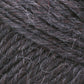 Close-up image of Brown Sheep's Lamb's Pride Bulky Yarn in dark grey and black. The densely intertwined fibers showcase a blend of thick and thin strands, some slightly frayed, giving the yarn a textured and rustic appearance that is perfect for knitters and crocheters crafting Icelandic sweaters.