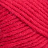 Close-up image of a ball of thick, bright red yarn. The strands are wound tightly together, showcasing their soft, fibrous texture—perfect for Brown Sheep's Lamb's Pride Worsted Yarn felting projects.