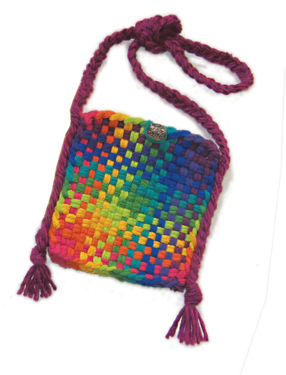 Introducing the Friendly Loom Potholder Purse Kit: a vibrant, small woven purse featuring a rainbow checkerboard pattern crafted from cotton loops. This charming pouch includes a purple braided strap with tassels on each end, made from purple yarn, and is secured with a textured metal button on the front.