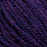 Close-up of Harrisville Shetland Yarn - Unwashed Cones by Harrisville Designs in deep purple. The image shows the soft texture and twisted strands, highlighting subtle variations in the purple hues—perfect for intricate Fair Isle knitting designs.