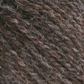 Close-up image of Bartlettyarns Maine Wool Yarn with visible fibers. The texture is slightly rough, indicating a blend of materials. The worsted weight yarn is tightly wound, showing multiple strands intertwined together, featuring heathered colors that highlight its Bartlettyarns origin.