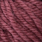 Close-up of thick, soft yarn in a warm, dusty rose color. The slightly fuzzy *Halcyon Yarn Classic Rug Wool* from *Caledonian Dye Works* showcases tightly twisted fibers clearly. This hand-dyed creation captures the intricate details of the strands and their gentle, plush appearance—a weaver's dream material.
